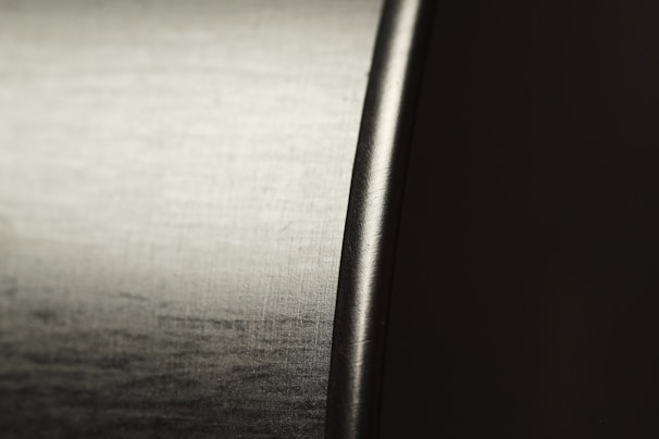 A high-resolution close-up of stainless steel 304 sheets with a polished finish reflecting light.