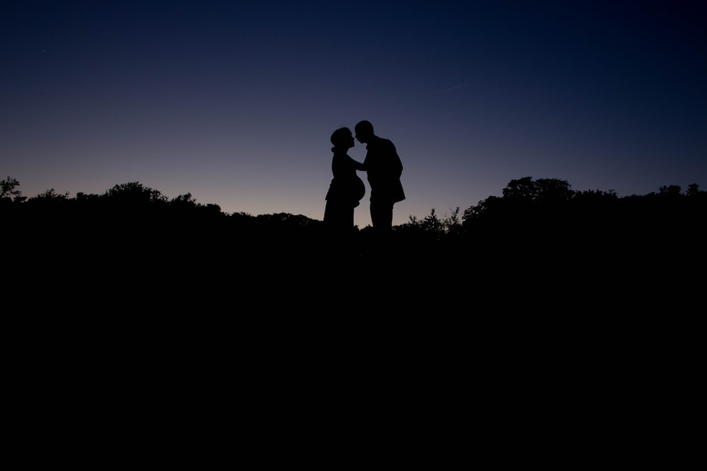 silhouette couple standing during golden hour