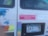 The image shows the back of a vehicle with multiple stickers and a Minnesota license plate (343 TTM). Some notable stickers include a pink one that reads 'The Women are coming. Expect Us.' and other stickers with various messages and colorful designs. The inside of the vehicle appears cluttered with different items visible through the window.