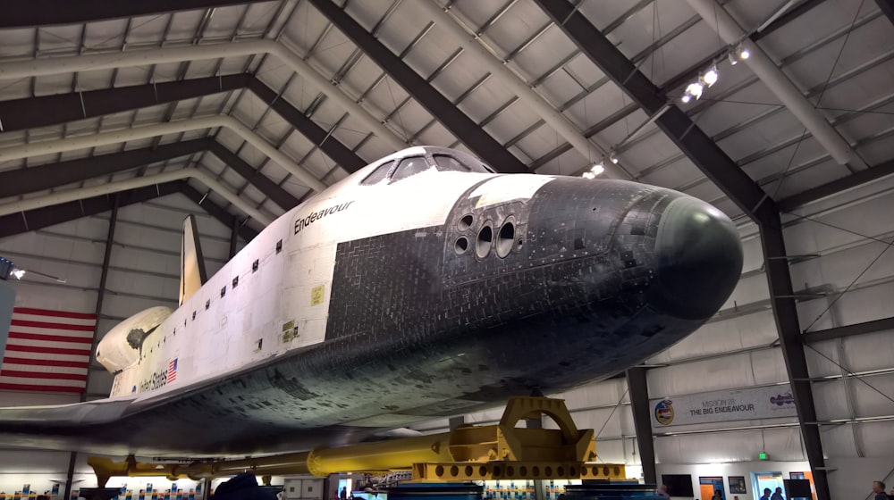 white and gray plane inside gray shed