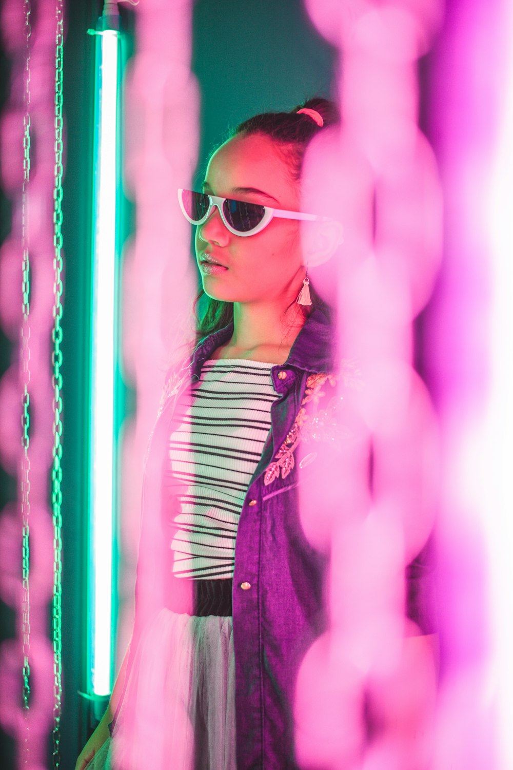 selective focus photography of woman standing beside fluorescent light