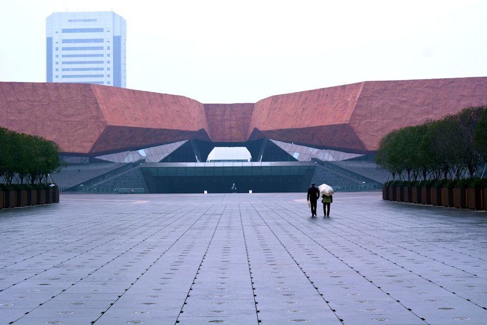 landscape photography of two person walking towards stadium