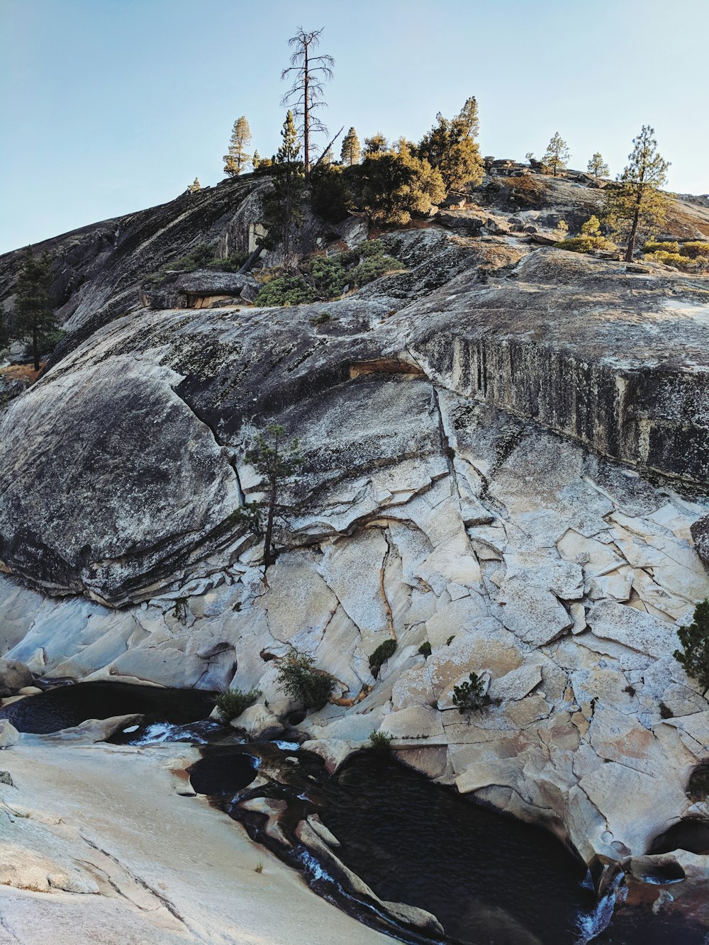 a rocky cliff with a small stream running between it