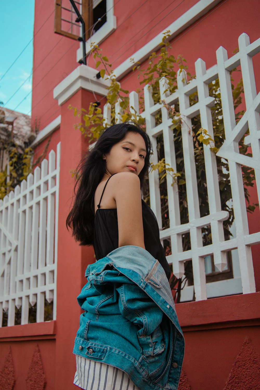 woman standing beside white fence