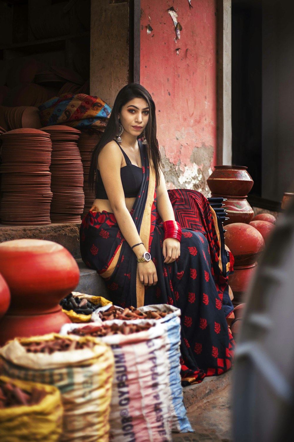 woman sitting surrounded by clay pots