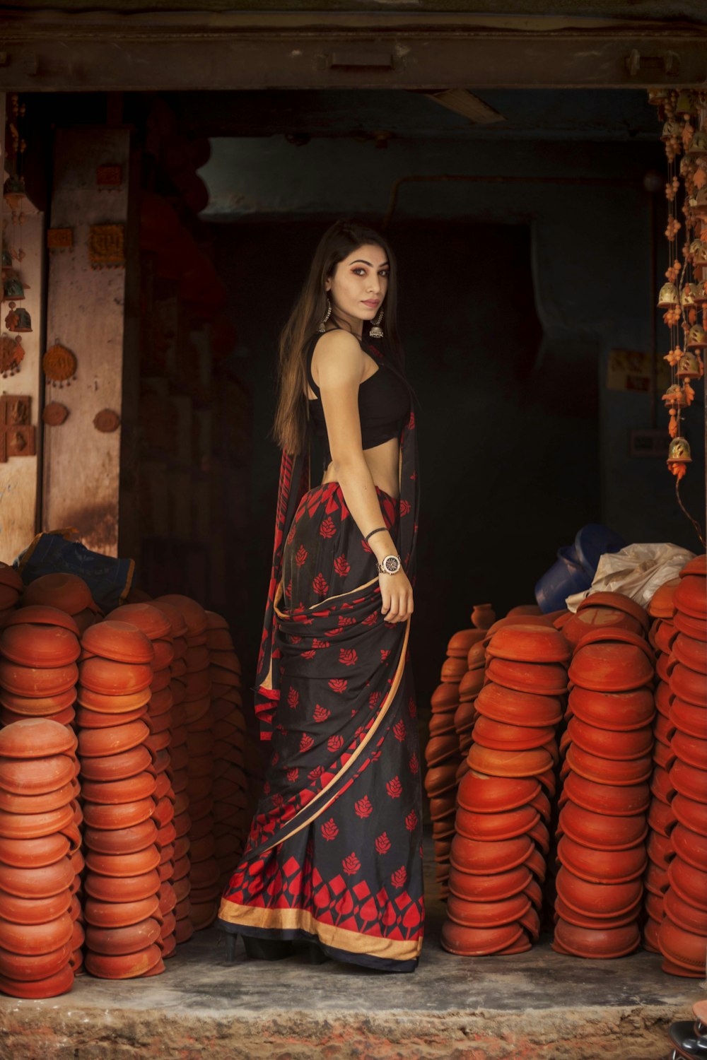 woman standing surrounded by clay pots