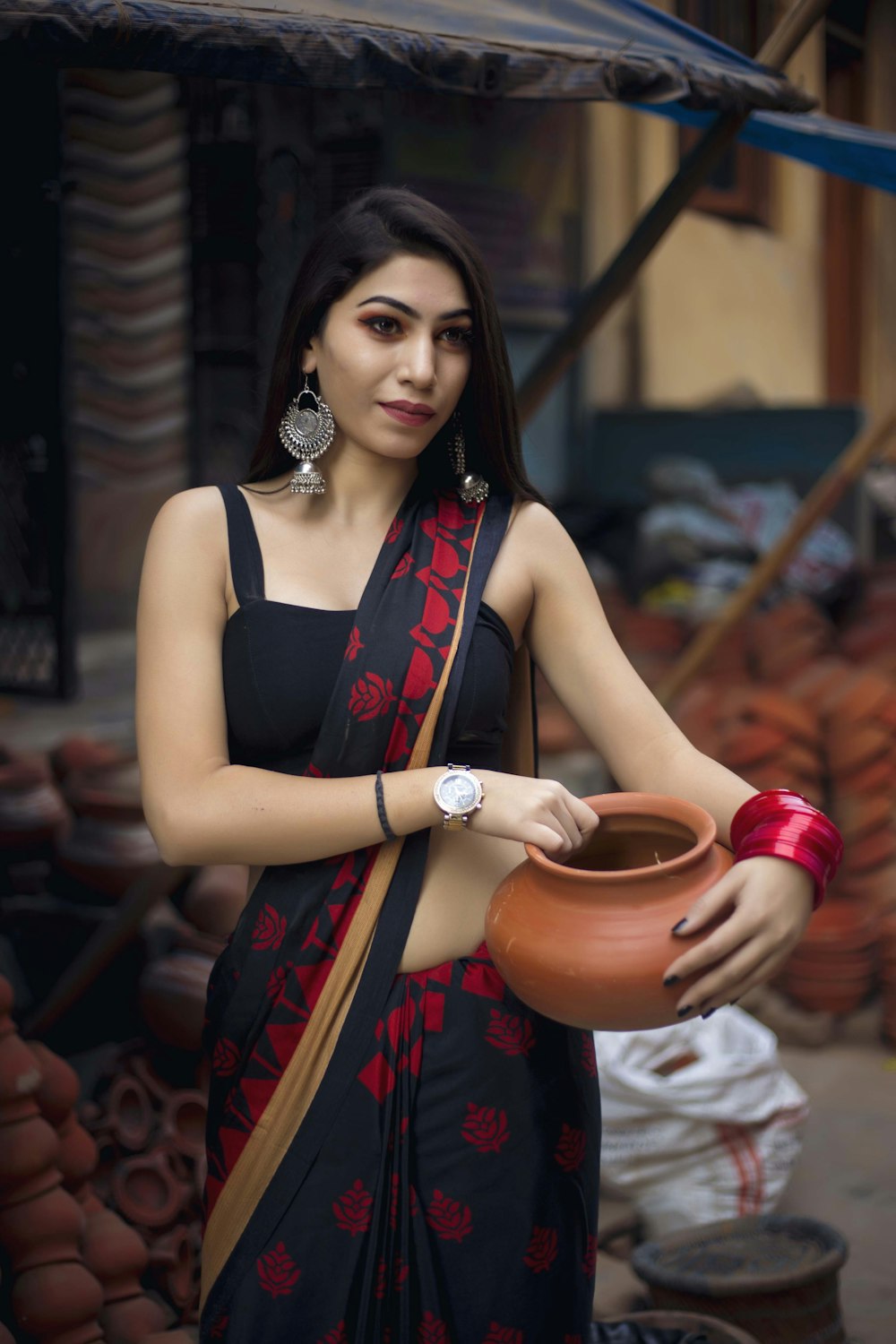 woman carrying brown clay pot