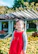 A smiling little girl twirling in a bright, stylish dress in a sunny garden.