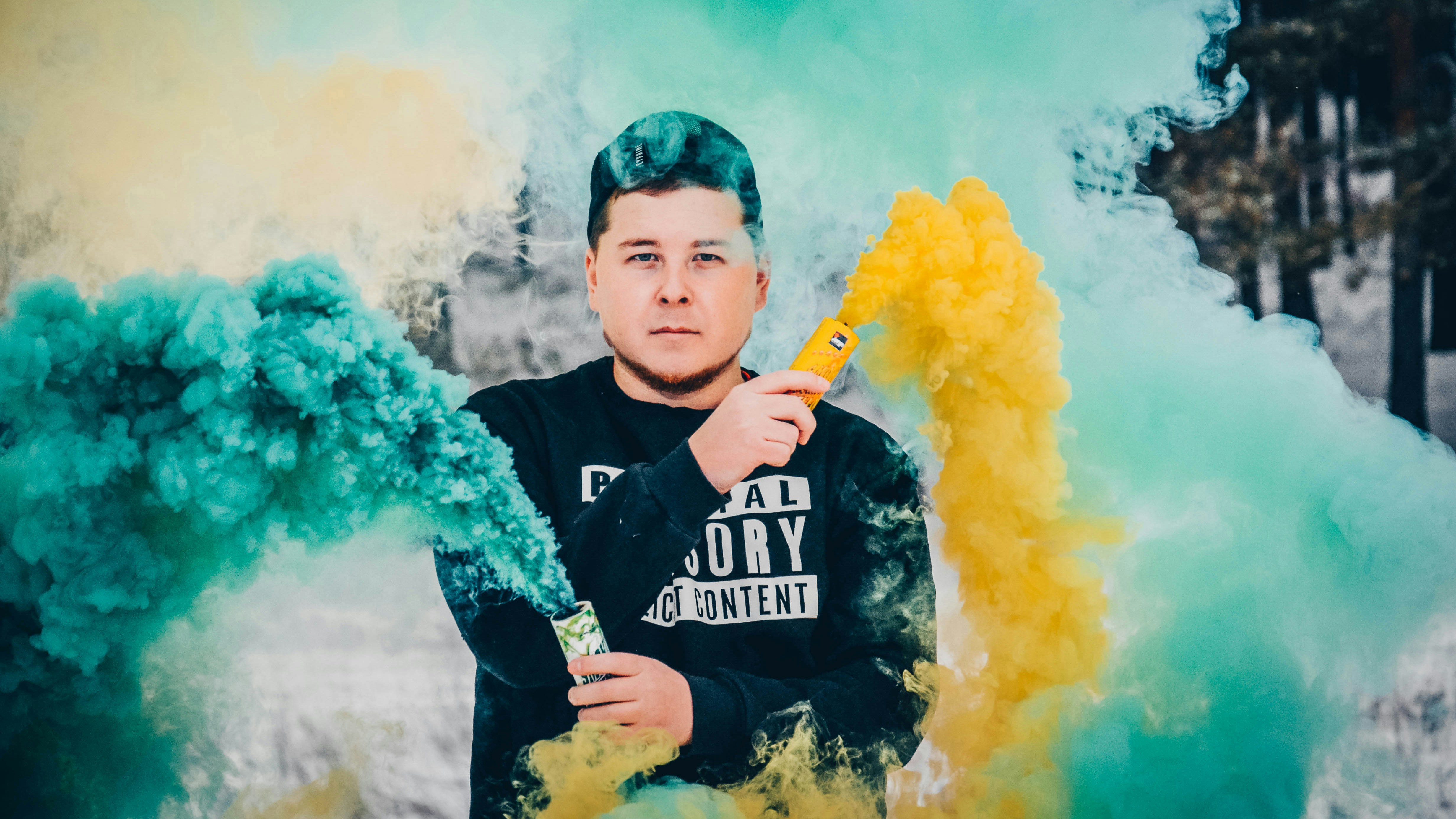 黄色と青の煙を吸う男