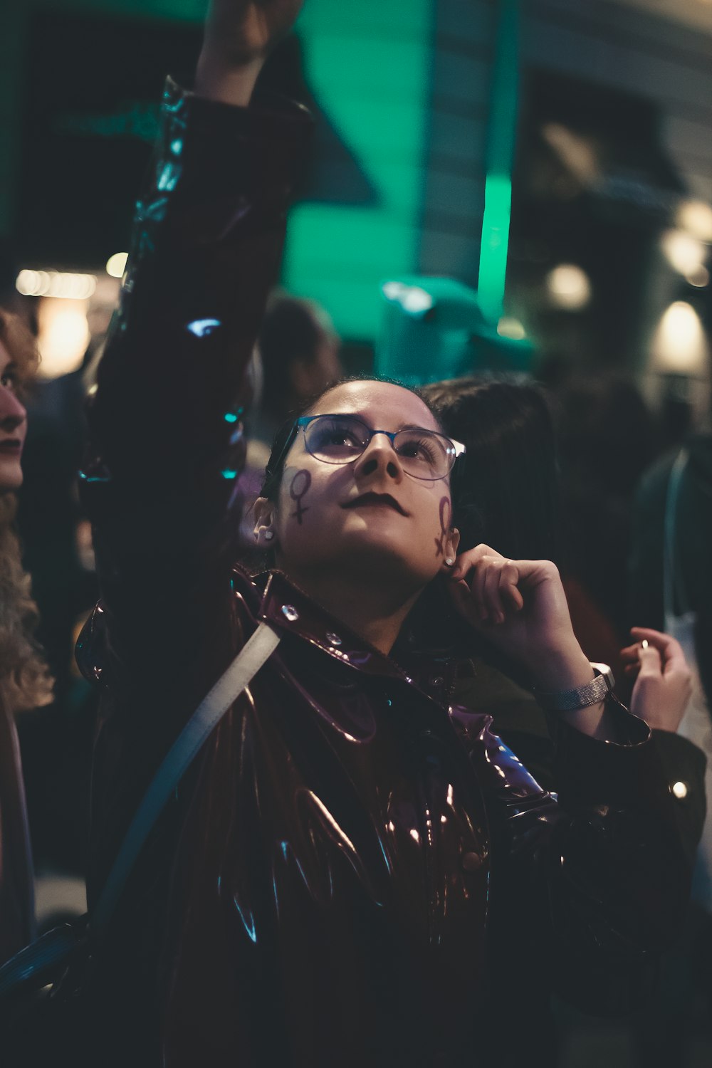 woman wearing maroon leather jacket with eyeglasses looking upward