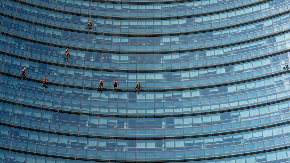 Menschen, die an einem Glasgebäude hängen