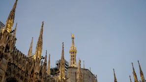 Close-up of intricate gothic details on Prague's St. Vitus Cathedral against a clear blue sky.