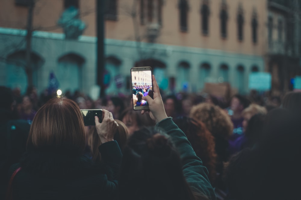 selective focus photography of person taking photo of building