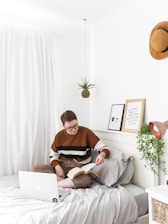 woman sitting on bed inside room