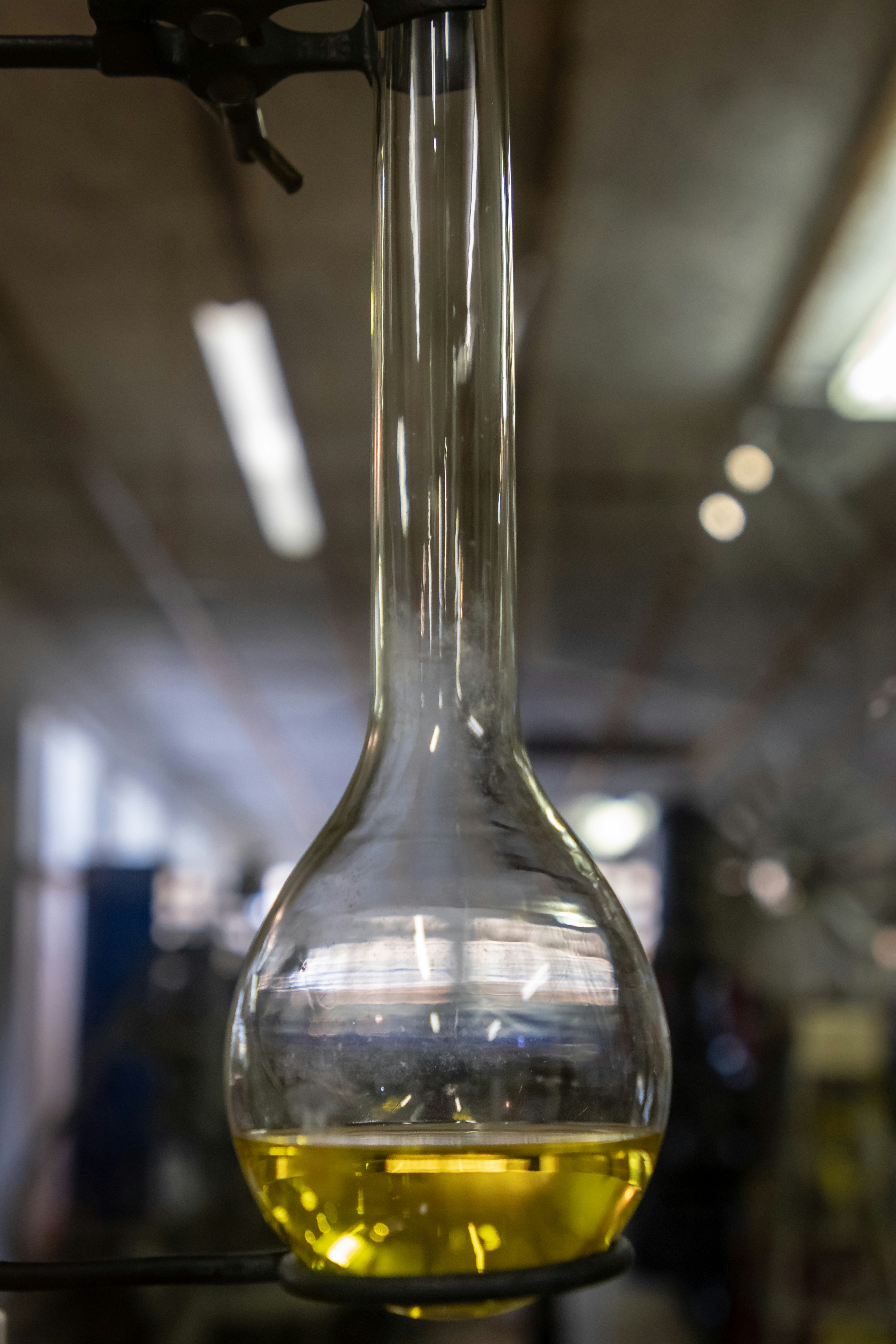Yellow viscous oil chemical in industrial drum in laboratory setting