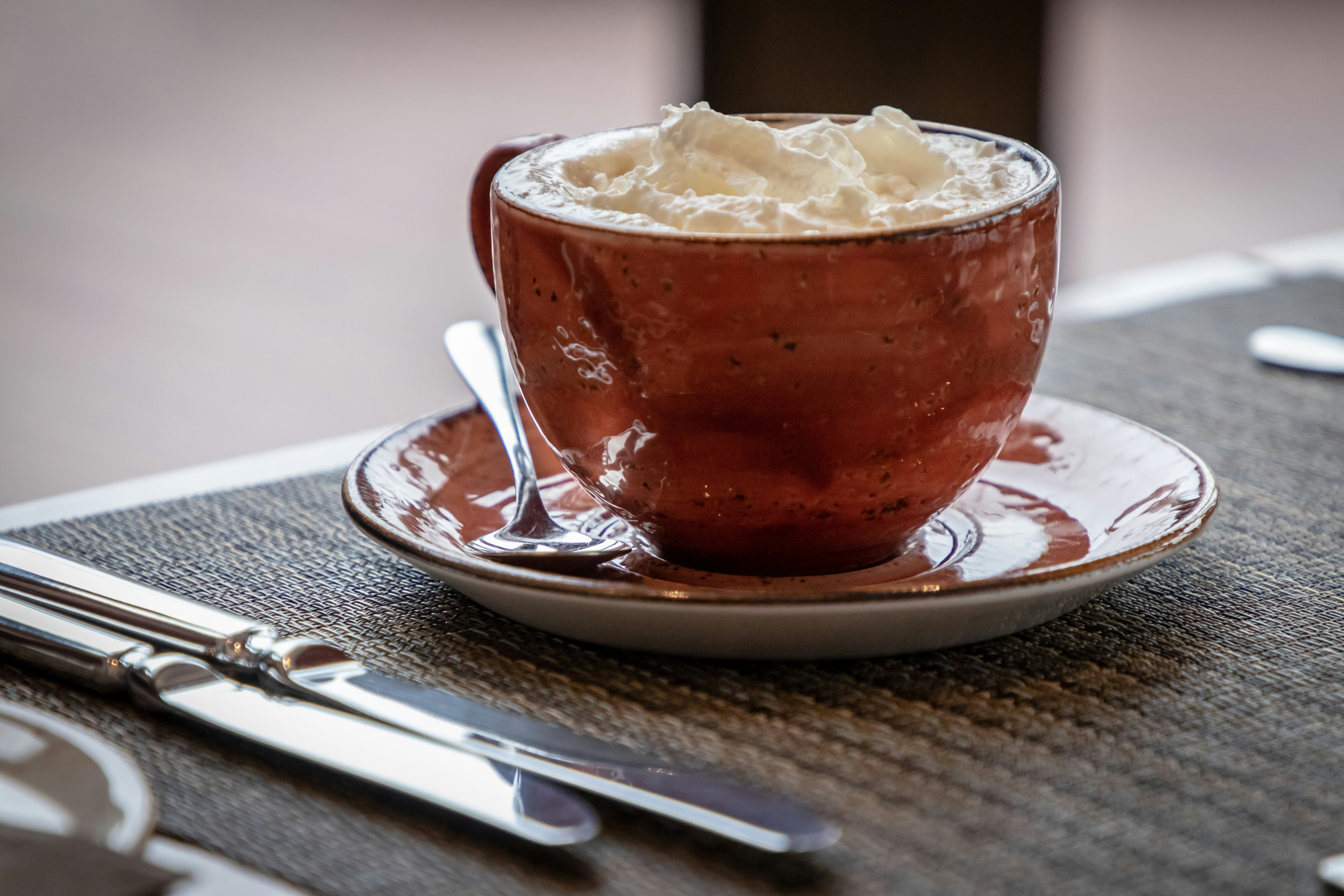 brown teacup with white cream