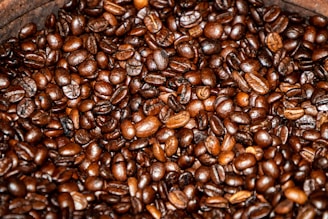 A close-up of freshly roasted coffee beans on a wooden table.