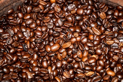 A close-up of freshly roasted coffee beans on a wooden table.