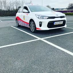 An ivv-certified driving school building with international flags outside.