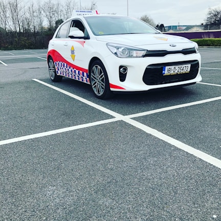 Instructor patiently guiding a beginner driver through parking practice on a quiet street.