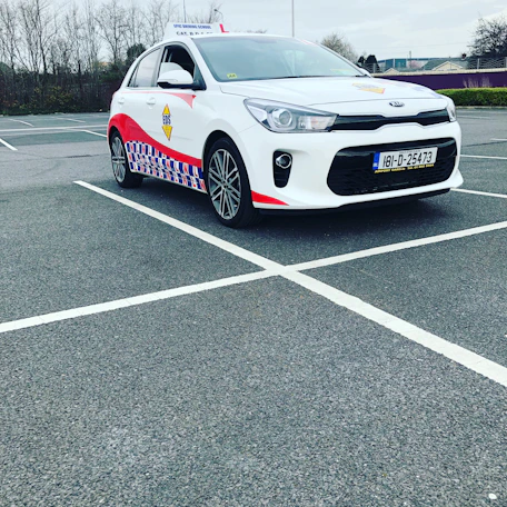 An ivv-certified driving school building with international flags outside.