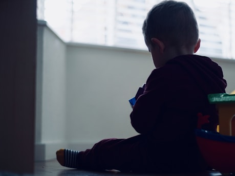 Children playing with colorful tactile toys in a warm, softly lit room.