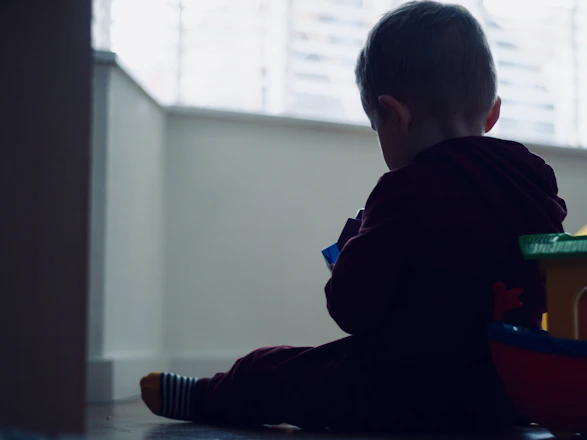 A joyful child playing with colorful educational toys in a bright room.