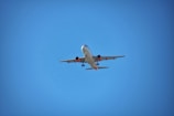 A sleek commercial airplane taxiing on the runway under a clear blue sky.