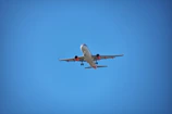 A panoramic view of a sleek commercial aircraft preparing for takeoff under a clear blue sky.