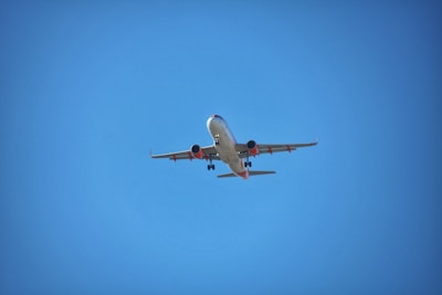 A sleek commercial airplane taxiing on the runway under a clear blue sky.