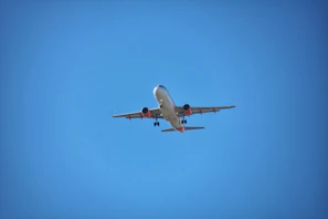 A panoramic view of a sleek commercial aircraft preparing for takeoff under a clear blue sky.