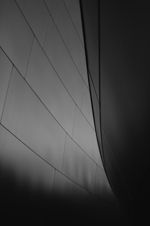 Stylish urban scene captured in monochrome, emphasizing shadows and architectural lines.