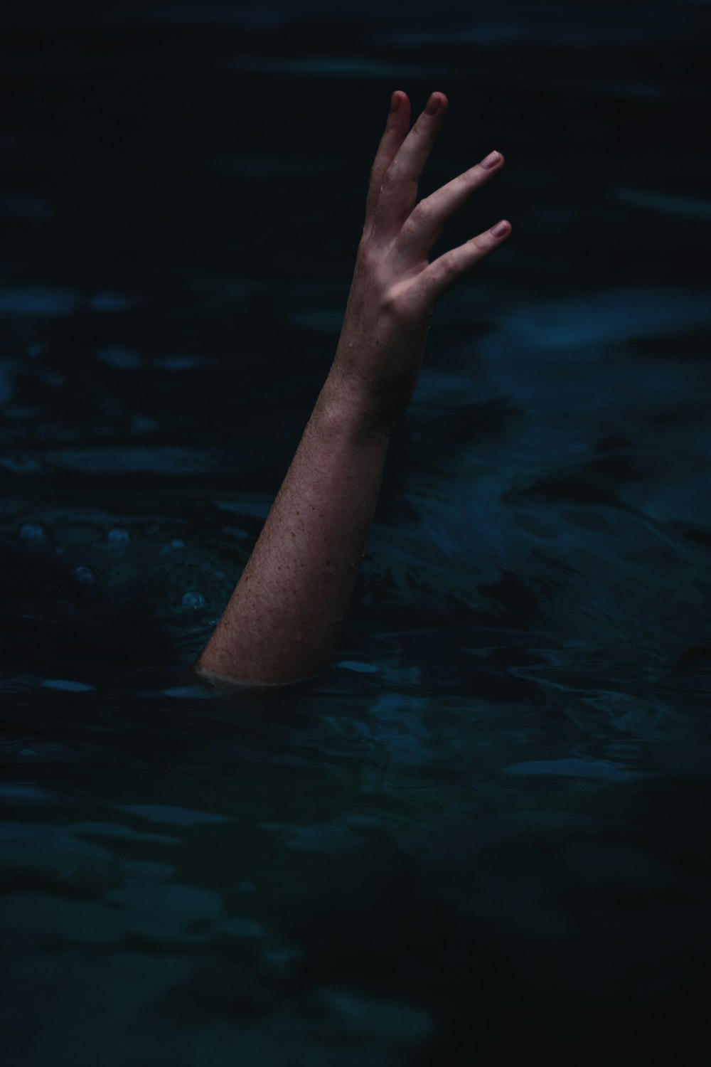person showing right hand from body of water