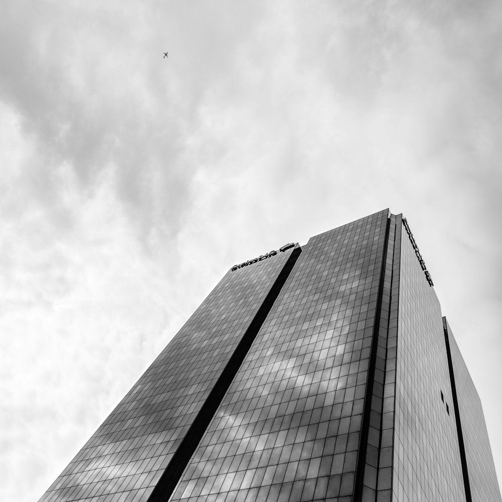 plane in mid air near high rise building