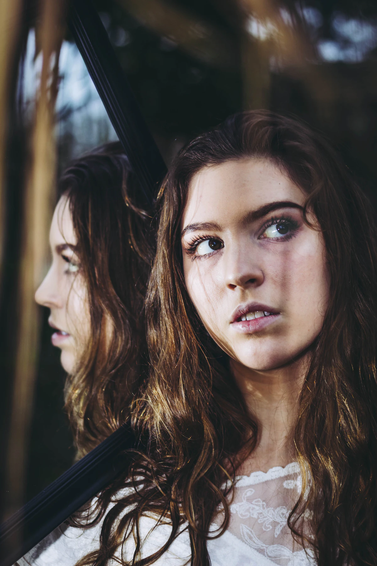 Close-up portrait of a woman looking sideways under soft natural light, with her nose bridge and profile visible, illustrating a nasal profile reviewed after nose filler treatment