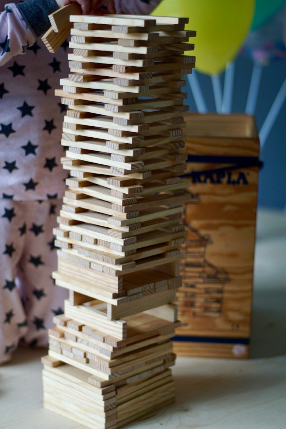 a person is building a tower of wooden blocks