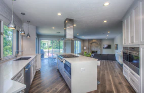 Newly remodeled kitchen with wood floors and white counters.