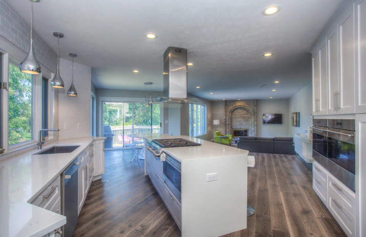 Newly remodeled kitchen with wood floors and white counters.