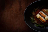 Close-up of a Scandinavian-style dish artfully plated in a rustic restaurant setting.