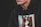 A person wearing a black hoodie with a graphic design featuring two faces on the front. The image is focused on the torso and part of the face. The hoodie has a drawstring with metal eyelets.