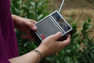person holding black and gray radio