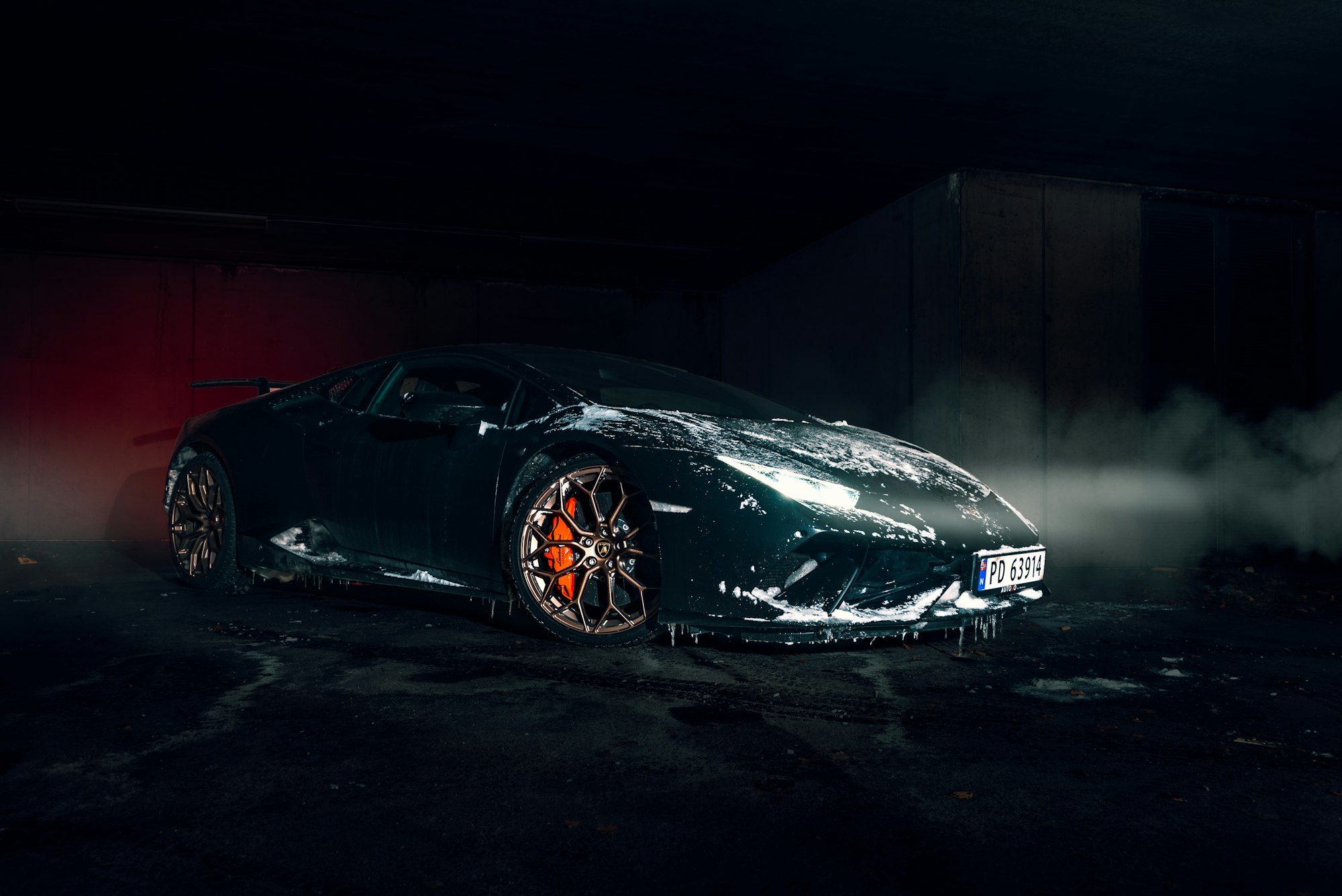 A dark supercar in a cloud of smoke