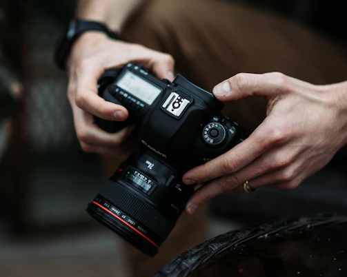 Close-up of a photographer adjusting camera settings on a DSLR.