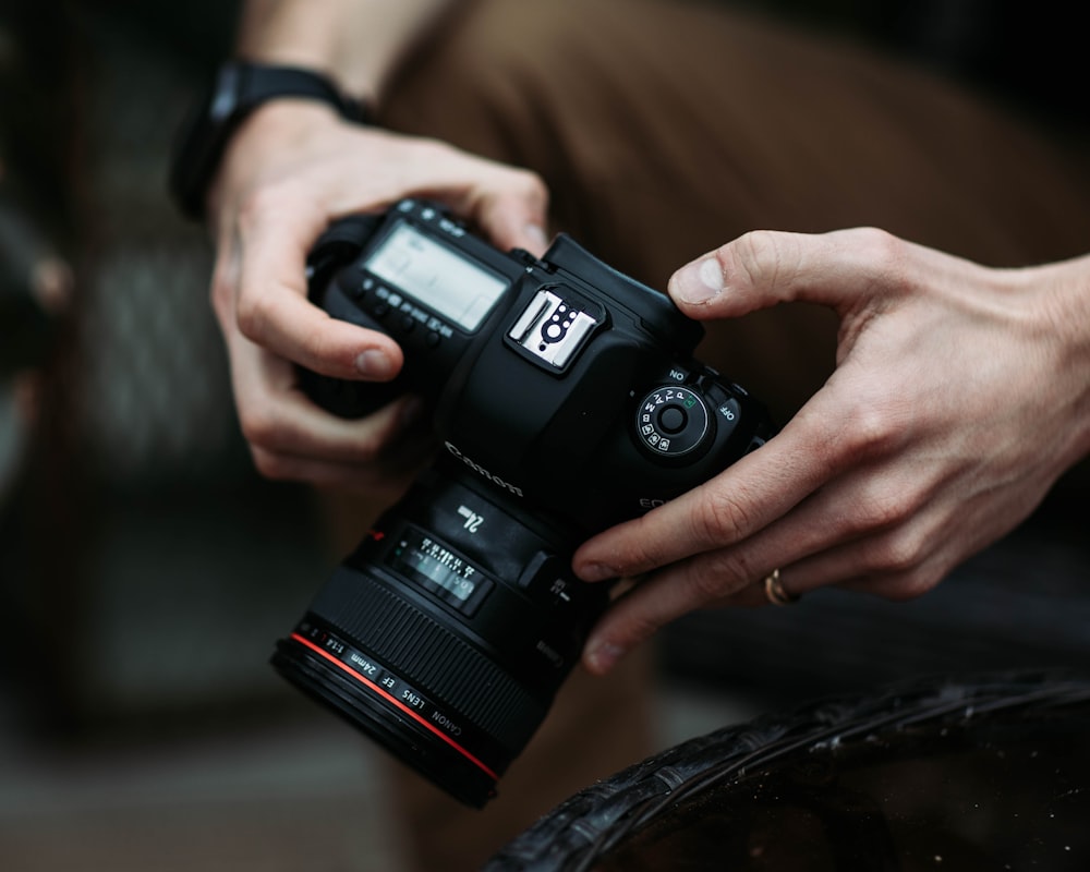 person holding black dslr camera