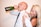 A man is drinking from a green bottle while a woman playfully covers his eyes and smiles. The man is wearing a white shirt and tie with lipstick marks on his cheek. The woman has long blonde hair and polished red nails.