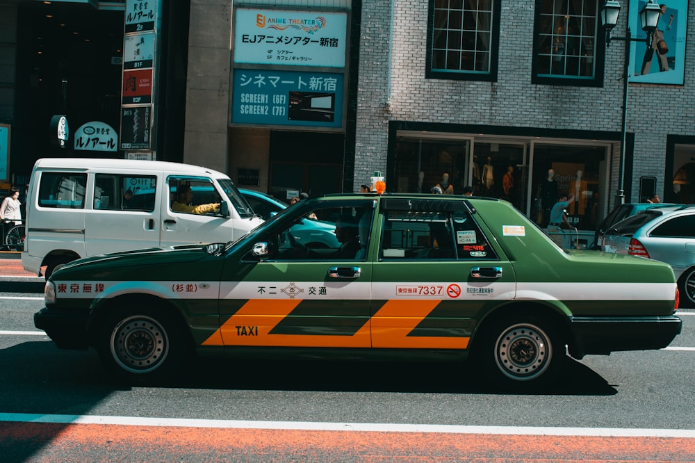 green sedan on road at daytime