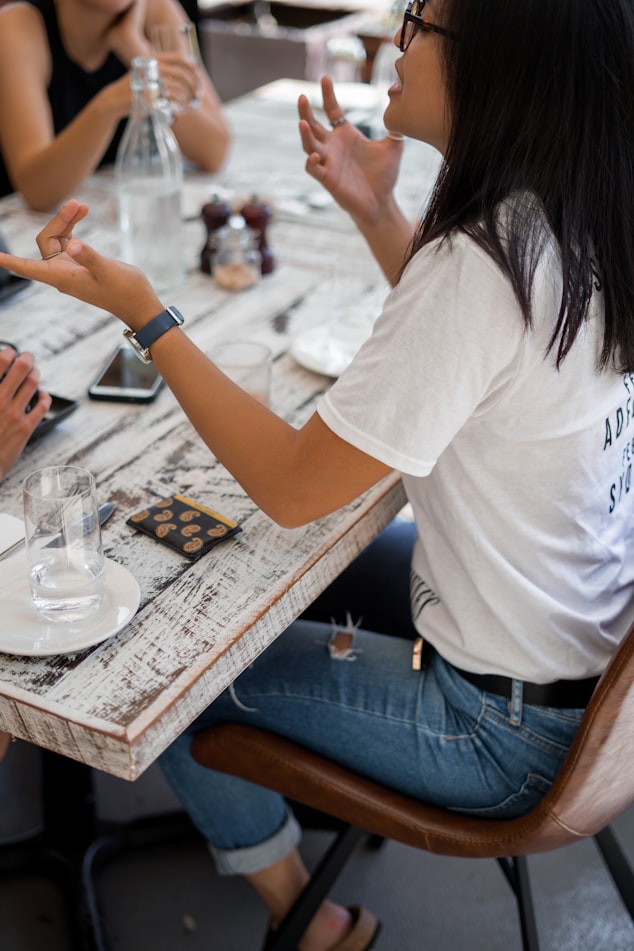 group of friends sitting at a table talking in a restaurant source credit photographer Jessica Da Rosaon Unsplash