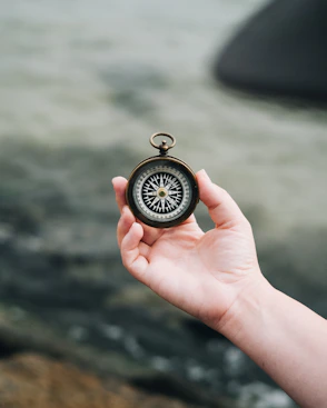 person holding white and black compass