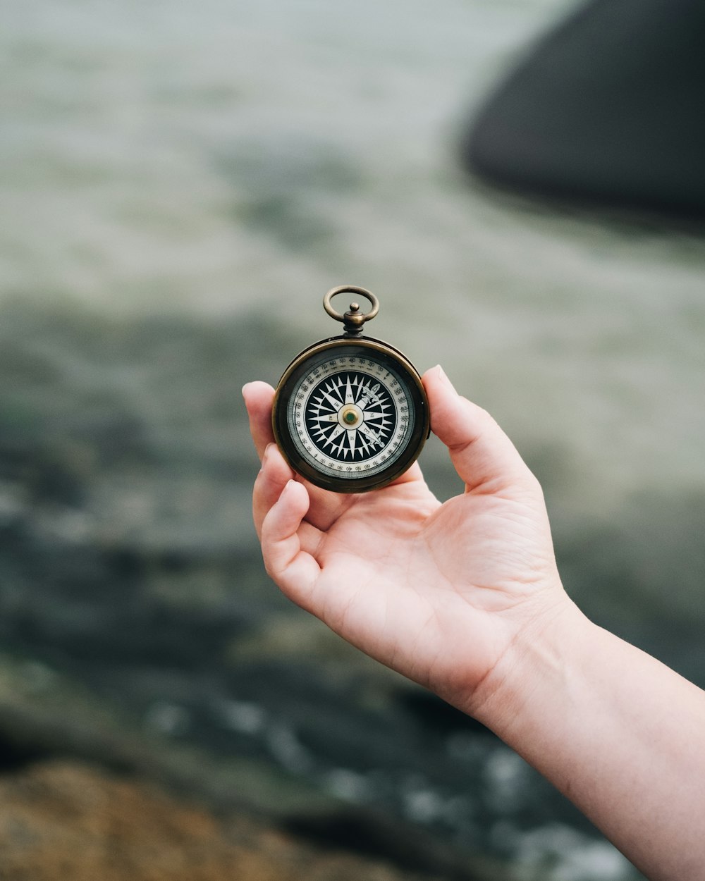 person holding white and black compass