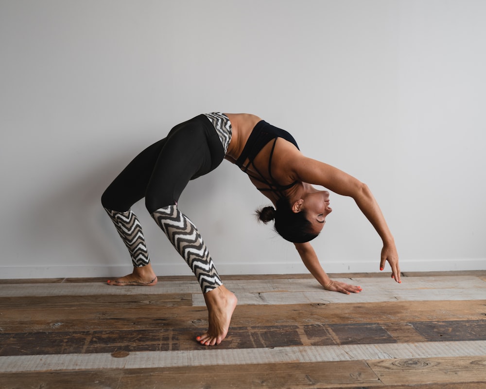 woman bending backwards beside wall